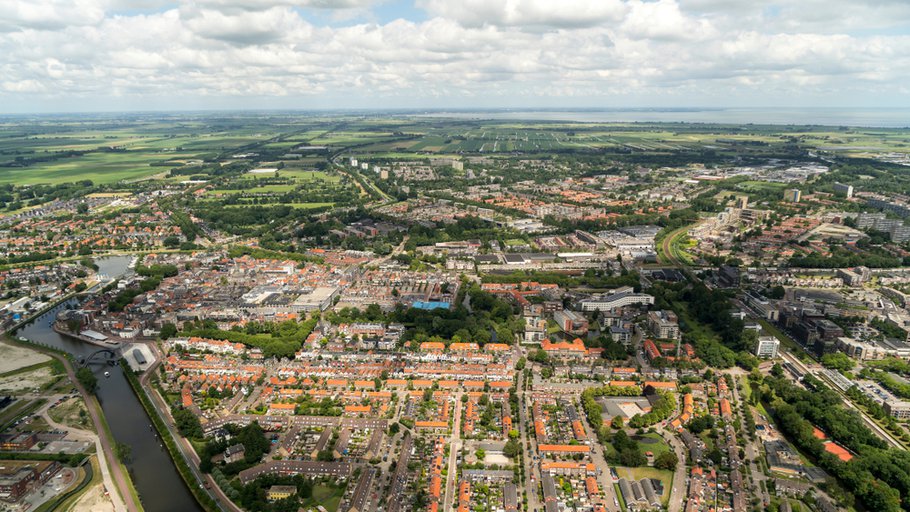Aerial view of Purmerend, a city in the province Noord-Holland in The Netherlands. Beautiful town with a crystal clear horizon with cumulus clouds.