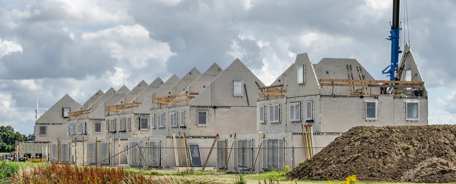 Numansdorp, The Netherlands, July 10, 2020: construction site of a row of terrace houses, with prefab concrete walls awaiting finishing under a dramatic sky