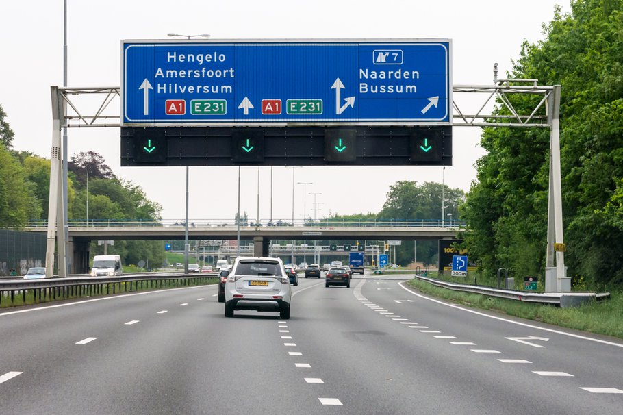 NAARDEN, NETHERLANDS - MAY 10, 2016: Traffic on motorway A1 and overhead route information signs, Naarden, North Holland