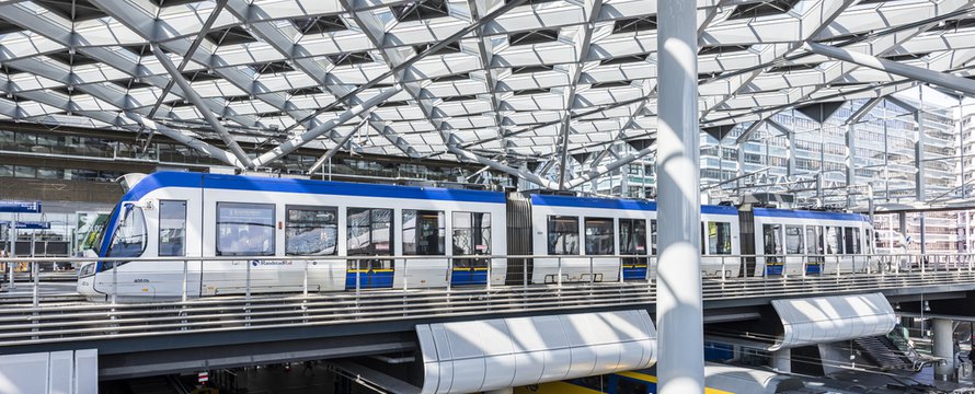 The Hague, The Netherlands - August 6, 2017: Central Train Station The Hague with construction, train, HTM tram, platforms and glass windows.